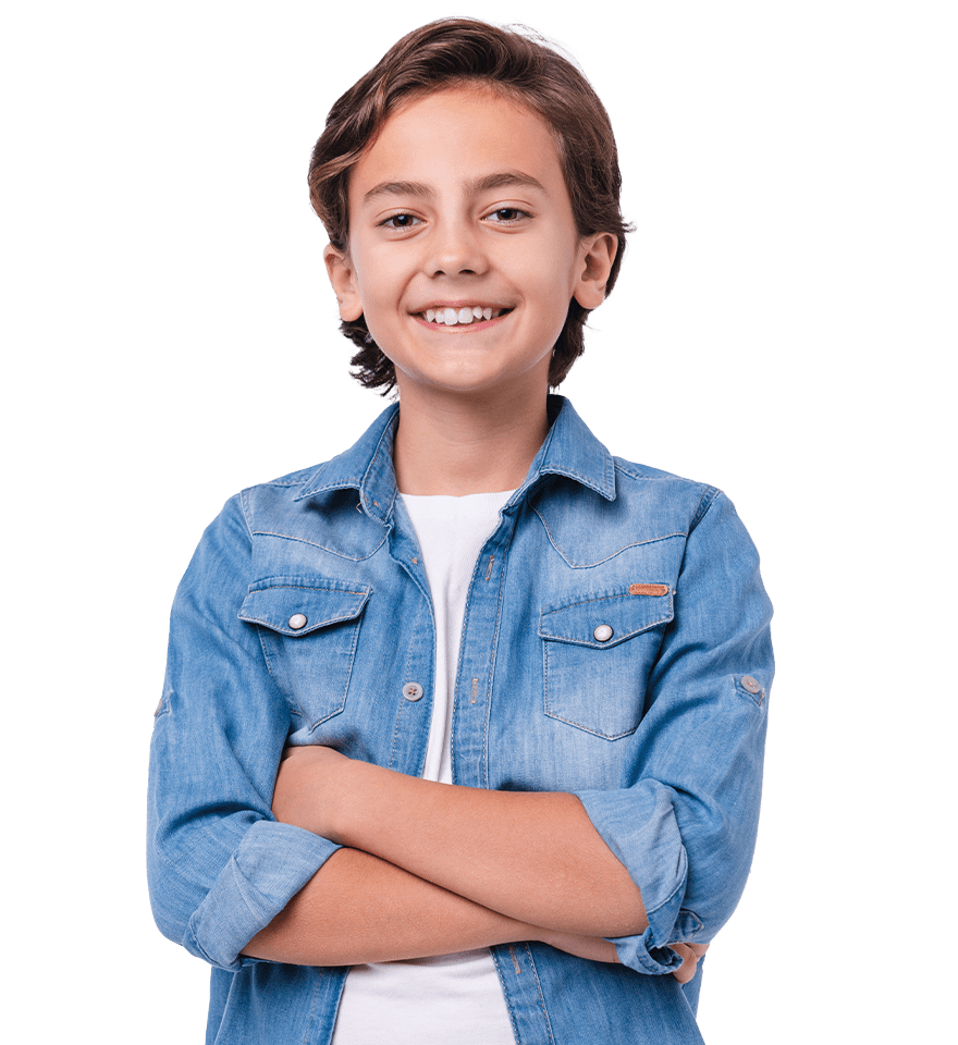 A young boy smiling, wearing a blue denim jacket over a white shirt, arms crossed