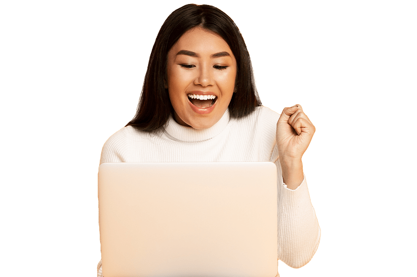 A joyful post-secondary school student using a laptop, celebrating success with a raised fist. She is wearing a white turtleneck sweater.