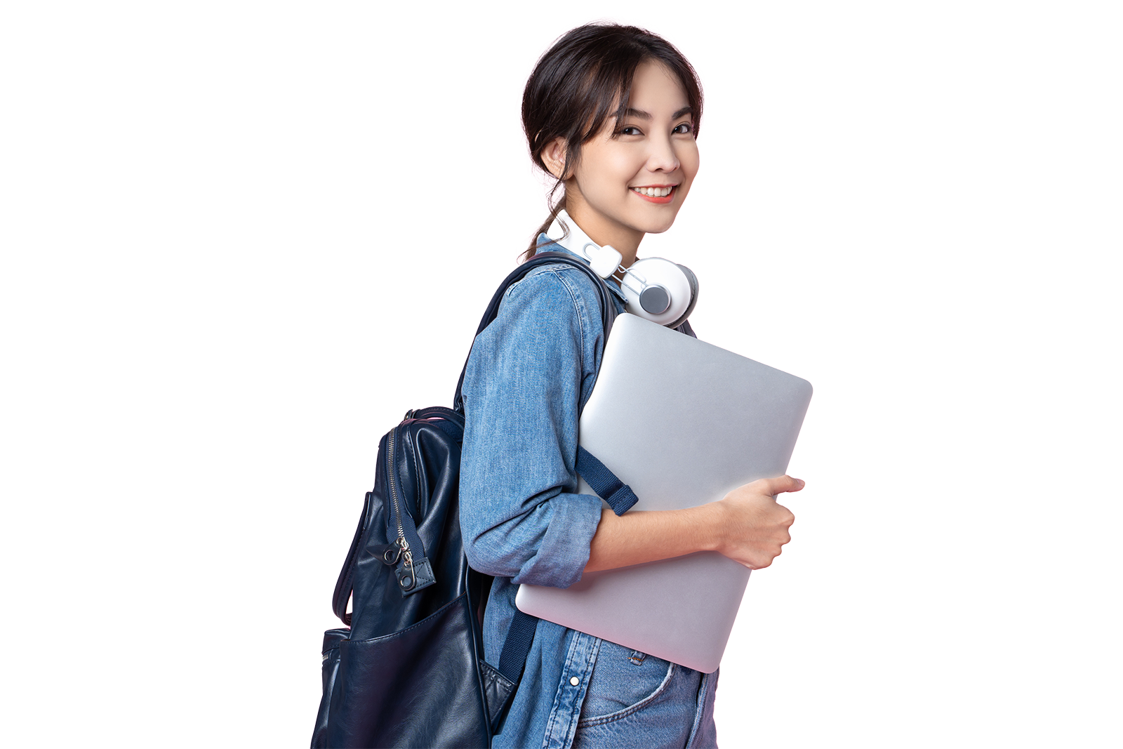 Teenage girl wearing a backpack, holding a laptop and wearing headphones around her neck
