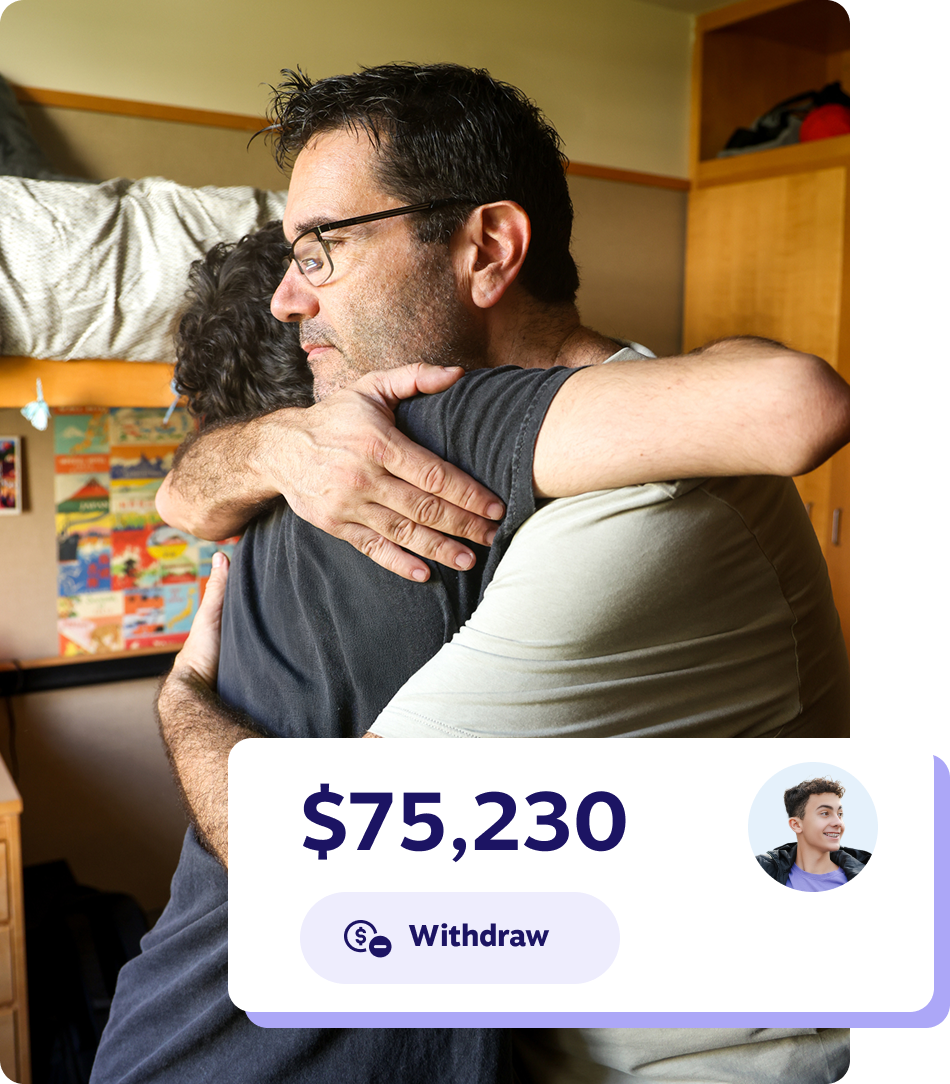 A man and his son sit together in their cozy dorm room, surrounded by books and personal items.