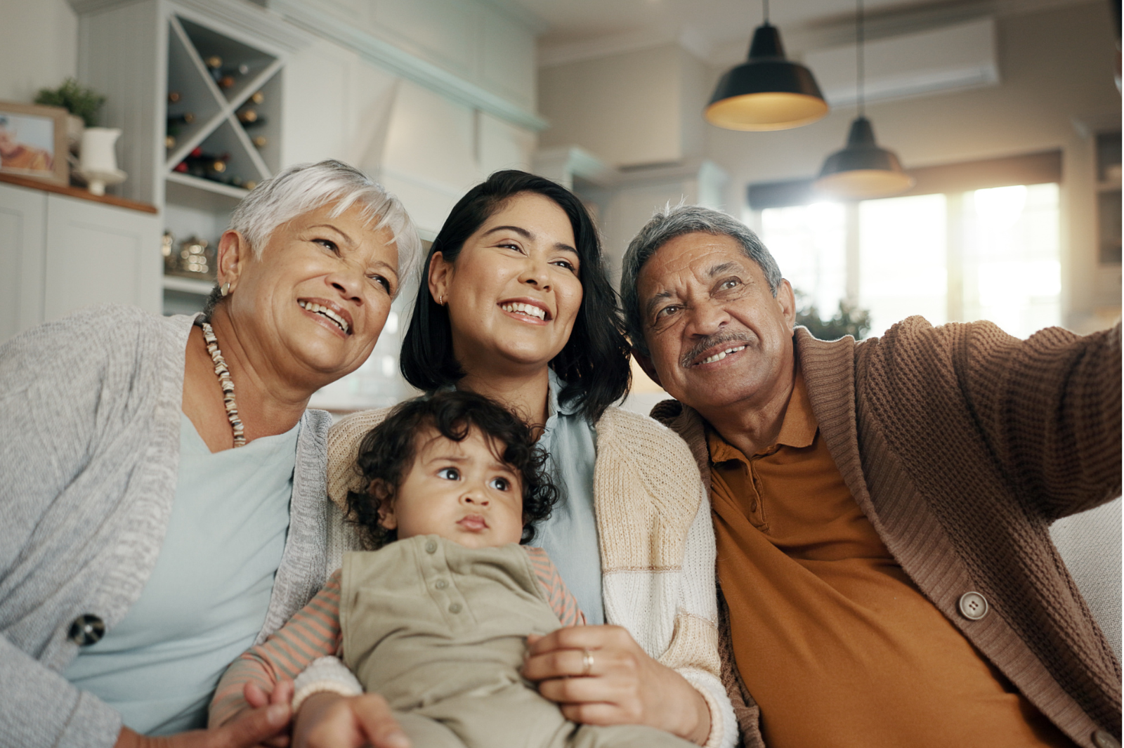 grandparents with daughter and grandchild taking a selfie.